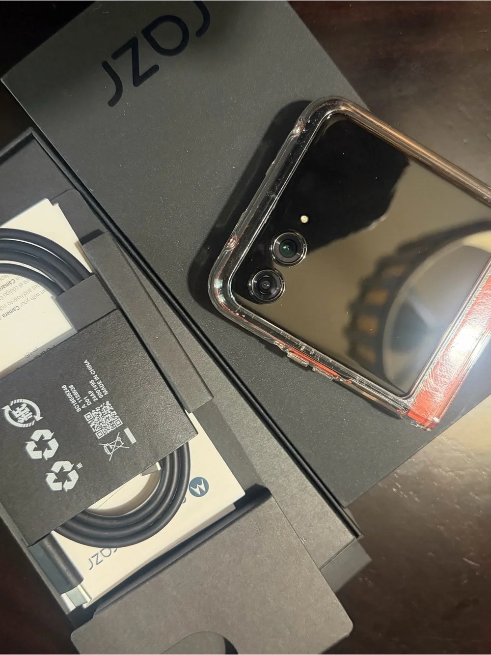 Motorola black smartphone with clear case and orange accents